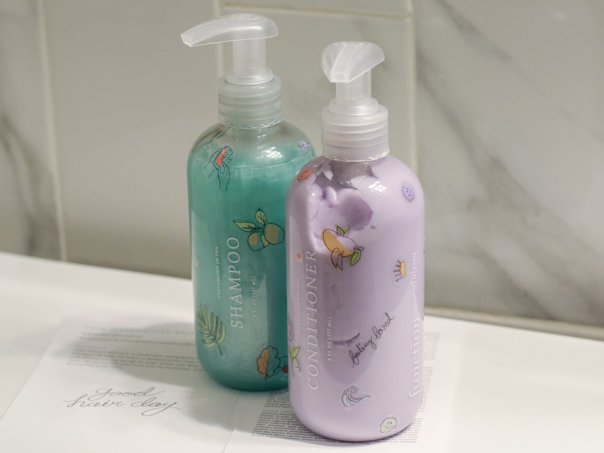 Alyssa's Function of Beauty custom haircare lineup includes: turquoise shampoo and purple conditioner.