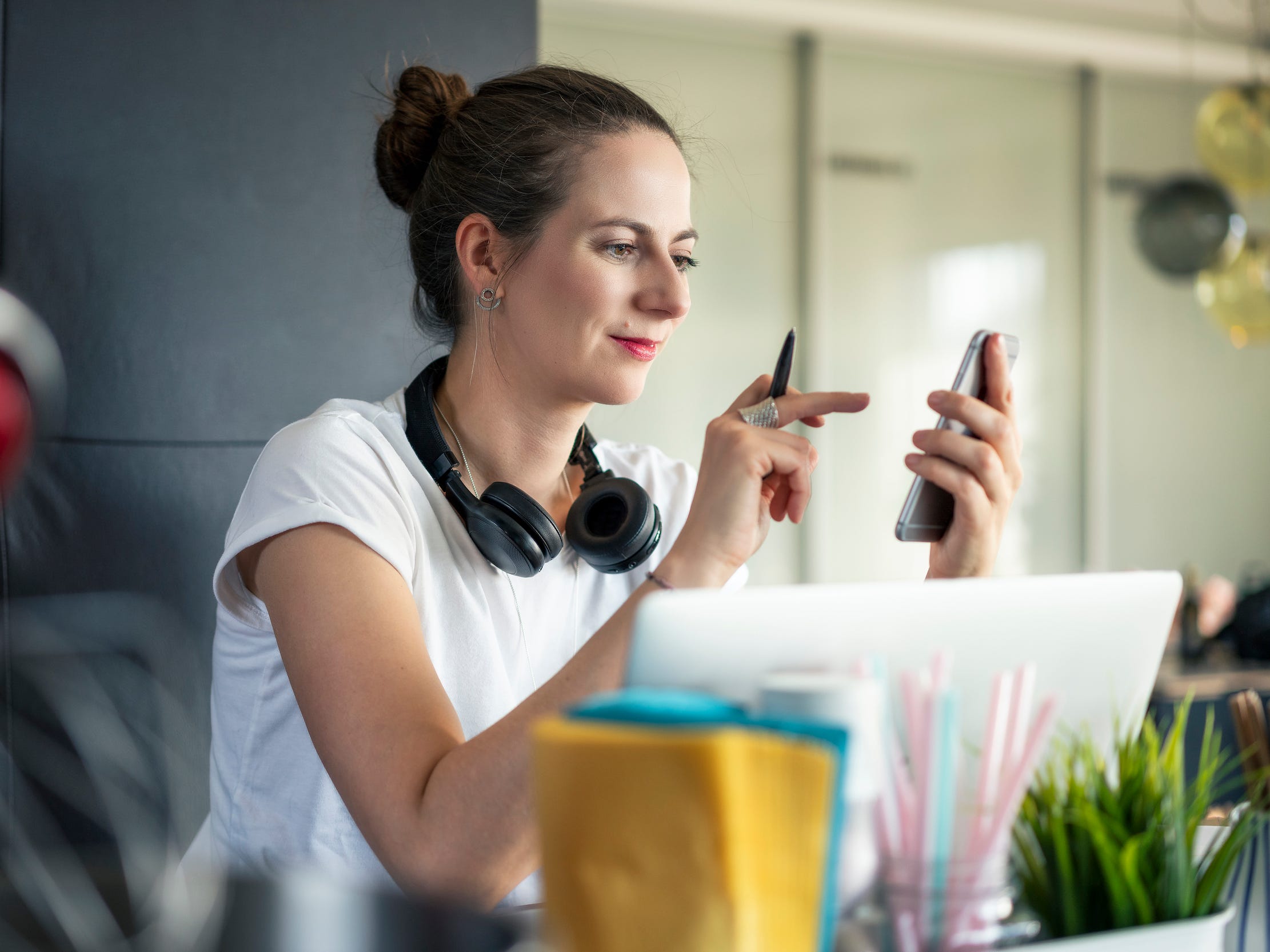 creative professional with smartphone laptop at home