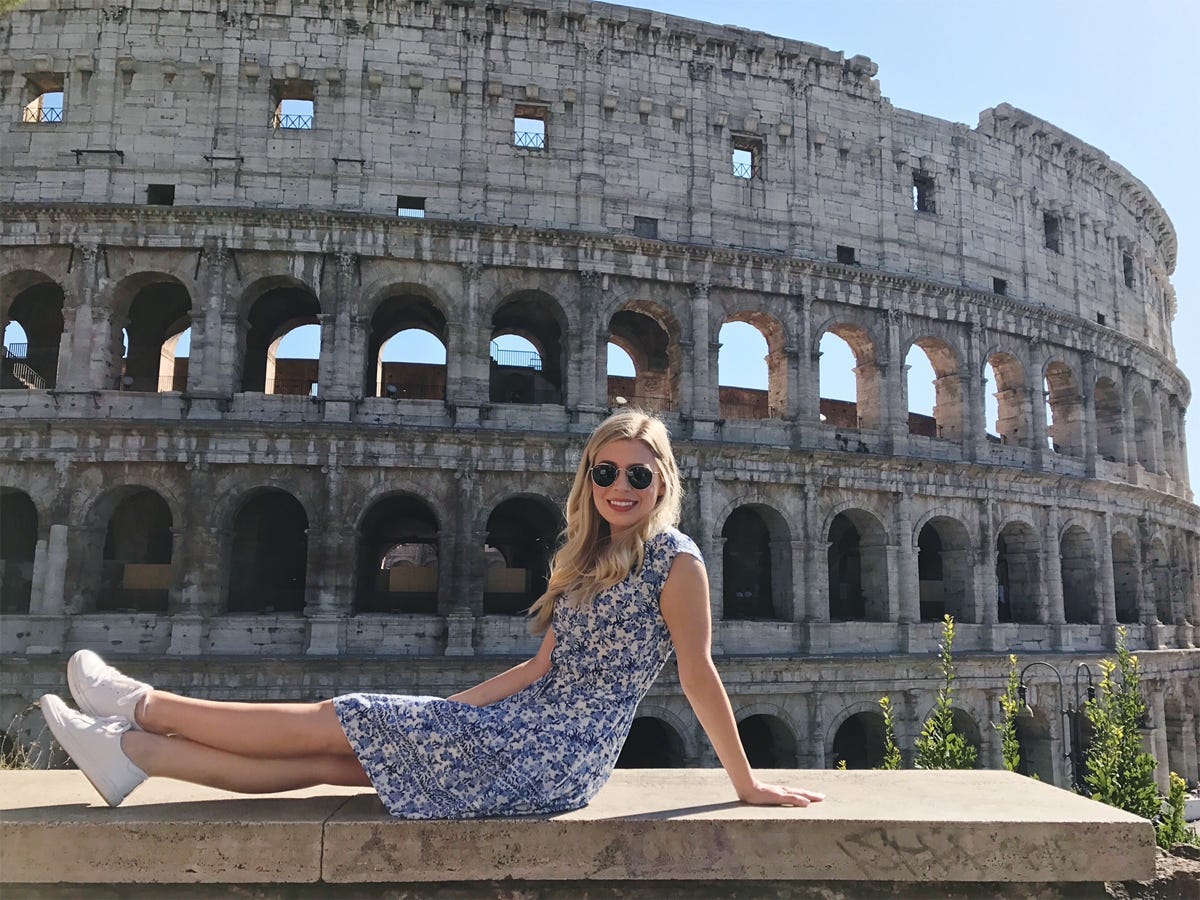 woman wearing a pair of ray ban sunglasses in front of the colosseum in Rome